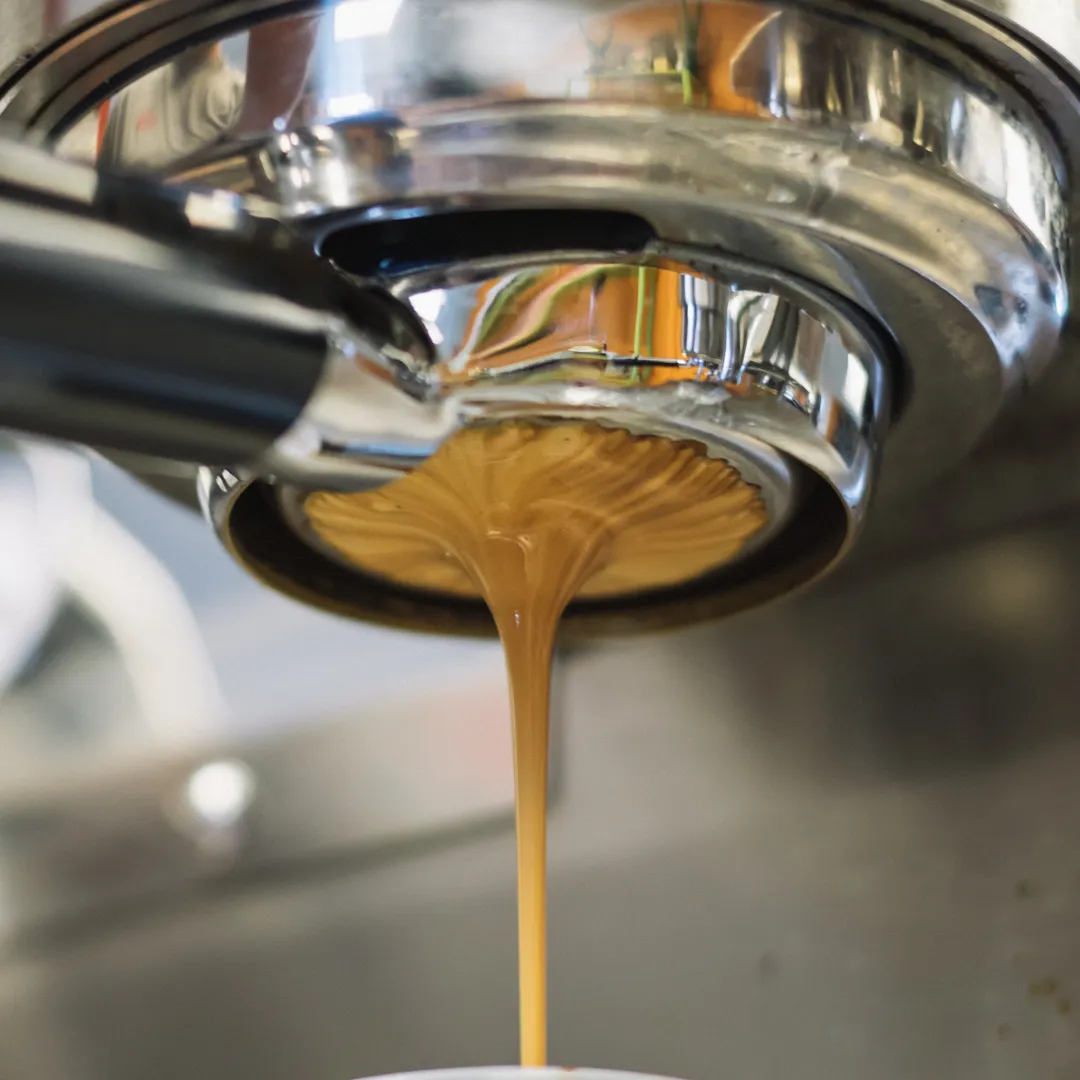Cafetera de espresso sirviendo café recién hecho