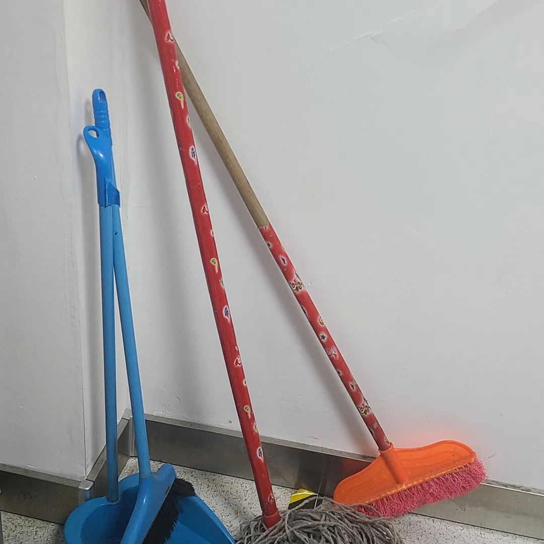 Escoba, recogedor y fregona apoyados en una pared