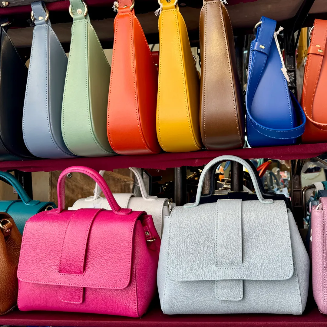 Bolsos de cuero de colores expuestos en un puesto