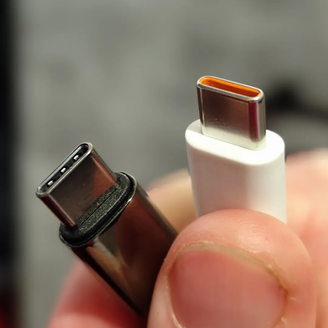 Dedos sujetando dos conectores USB-C