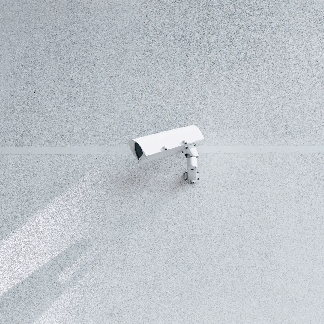 Cámara de seguridad blanca en una pared blanca