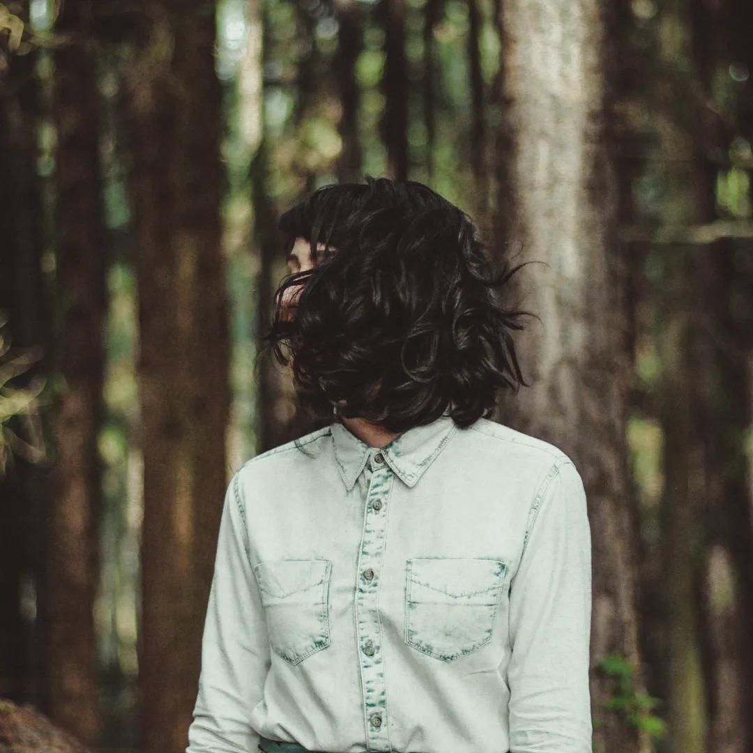 Persona con camisa clara en un bosque