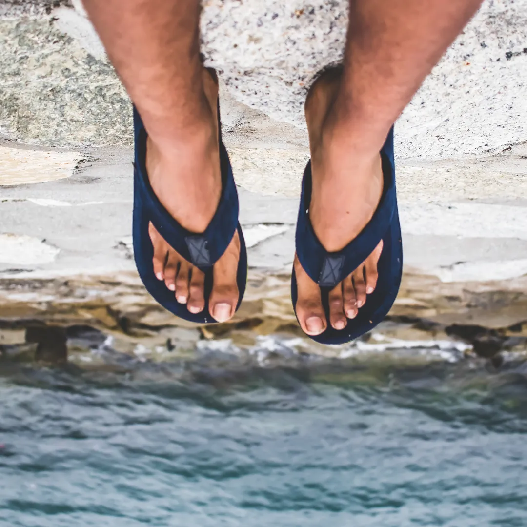 Pies con chanclas sobre el agua