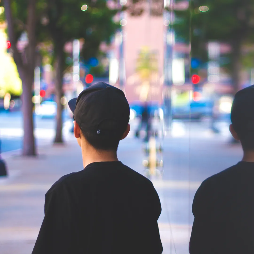 Dos personas de espaldas con gorra en una calle