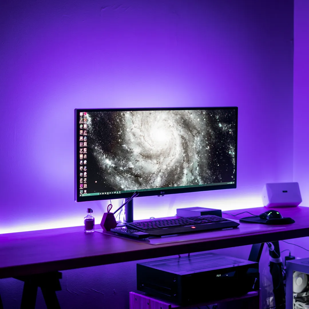 Monitor en un escritorio iluminado con luz morada