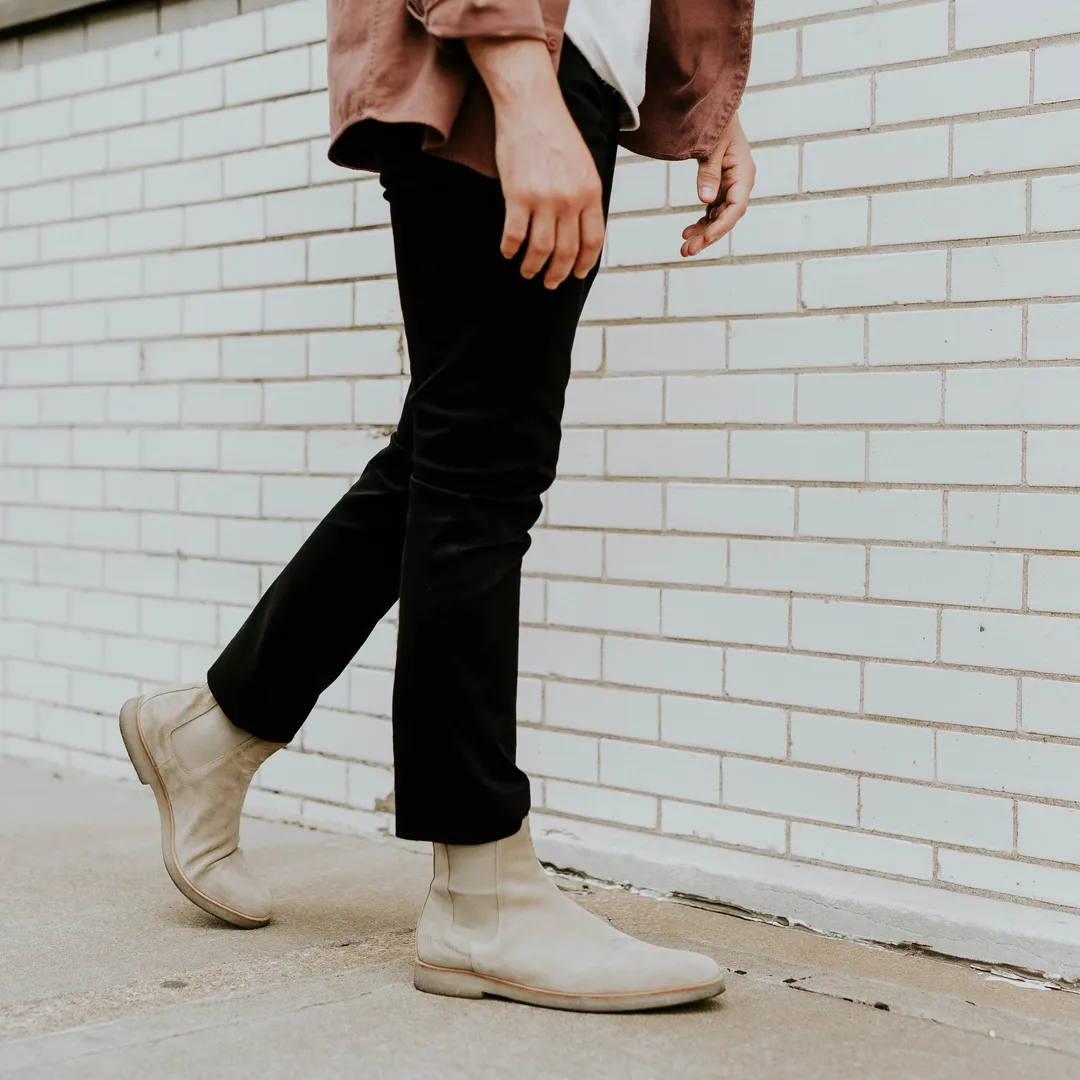 Persona caminando con pantalón negro y zapatillas blancas