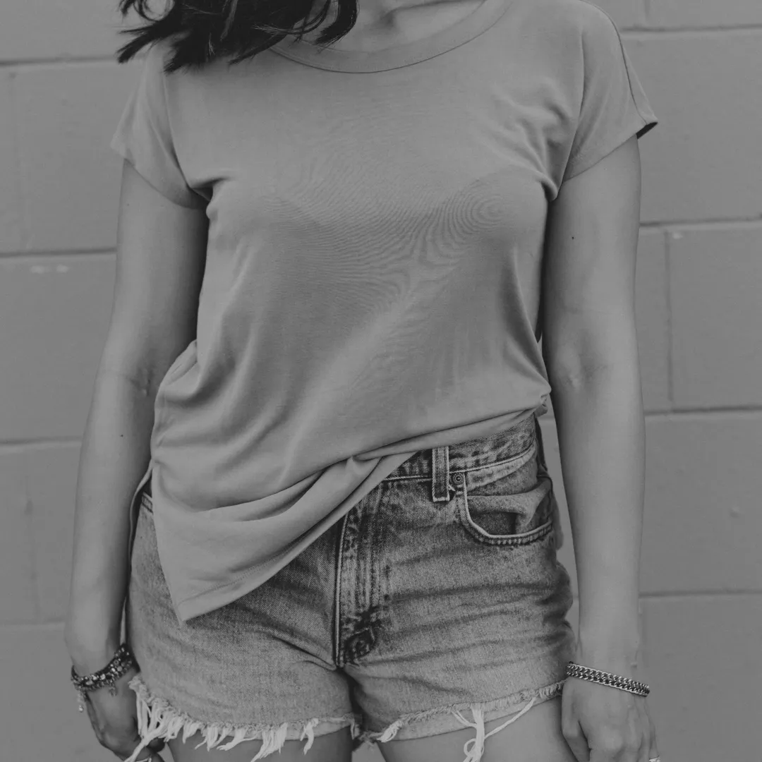 Persona con camiseta y pantalones cortos vaqueros, en blanco y negro
