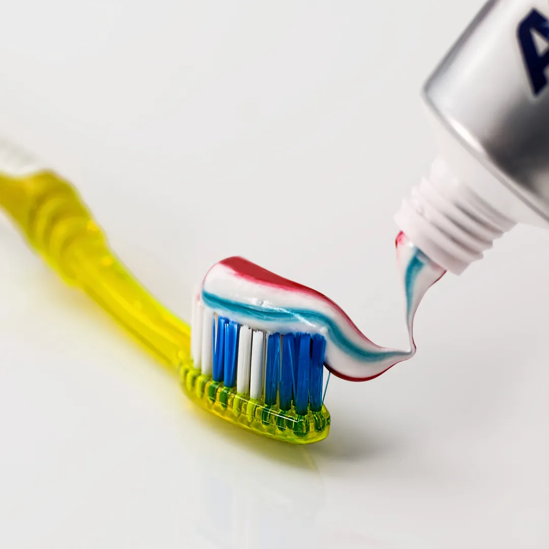 Pasta de dientes saliendo del tubo sobre un cepillo
