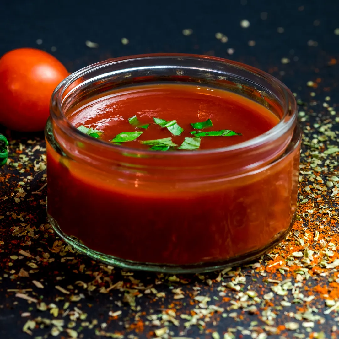 Tarro de salsa de tomate con tomates frescos