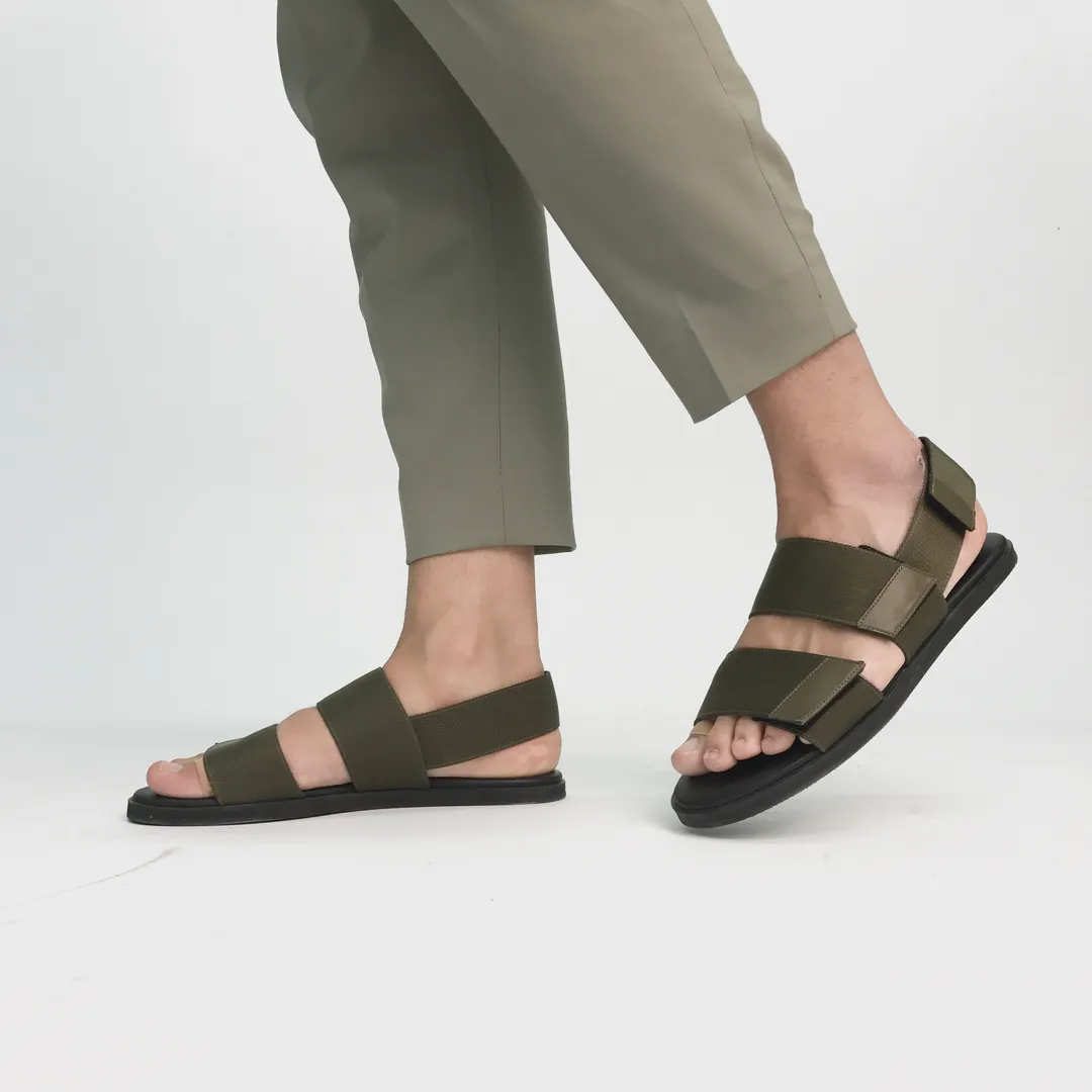 Pies con sandalias marrones sobre fondo blanco