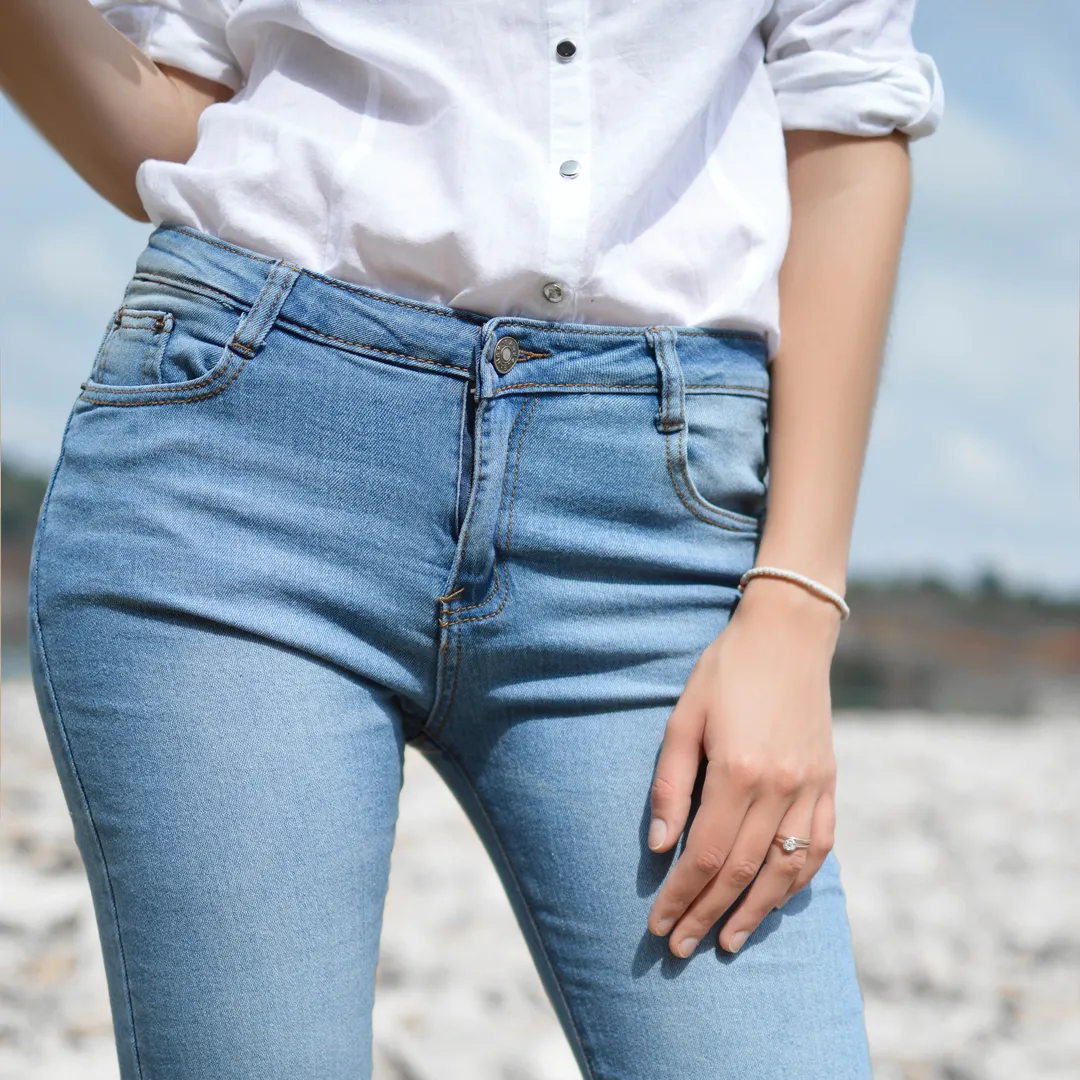 Persona con vaqueros azules y camisa blanca